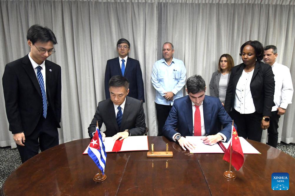 Imagen del 12 de diciembre de 2024 del embajador chino en Cuba, Hua Xin (2-i-frente), y el viceministro primero cubano del Comercio exterior y la Inversión extranjera, Carlos Luis Jorge (2-d-frente), suscribiendo documentos en una ceremonia de firma para la instalación de parques fotovoltaicos, en La Habana, capital de Cuba. Los gobiernos de China y Cuba realizaron el jueves en La Habana un canje de firmas para oficializar la construcción en la isla caribeña de varios parques fotovoltaicos, apoyados con recursos donados por China. (Xinhua/Joaquín Hernández)