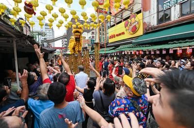 Personas observan la presentación de la danza del león en celebración del Festival de las Linternas en la calle Petaling, en Kuala Lumpur, Malasia, el 12 de febrero de 2025. (Xinhua/Chong Voon Chung)