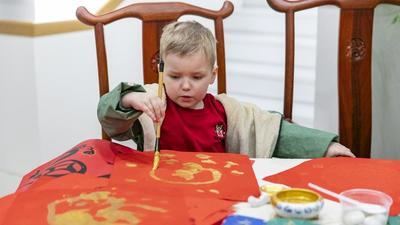 Un niño escribe el carácter chino 'Fu', que significa buena fortuna, durante una exposición sobre el zodiaco chino en el Centro Cultural de China en Belgrado, Serbia, el 12 de febrero de 2025. (Xinhua/Wang Wei)
